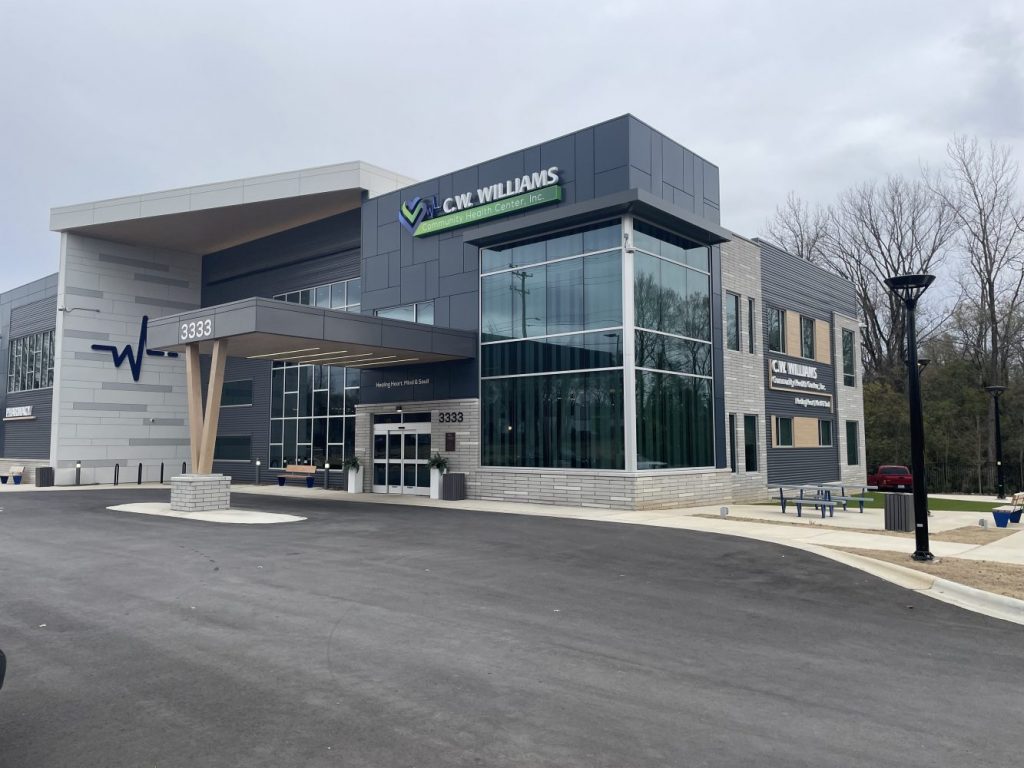 Modern healthcare building with large glass windows, sign reading